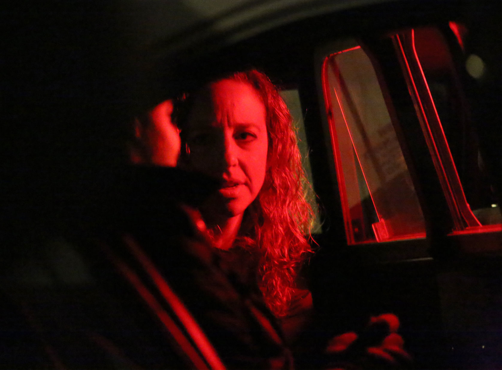 Sarah in red light talking to man